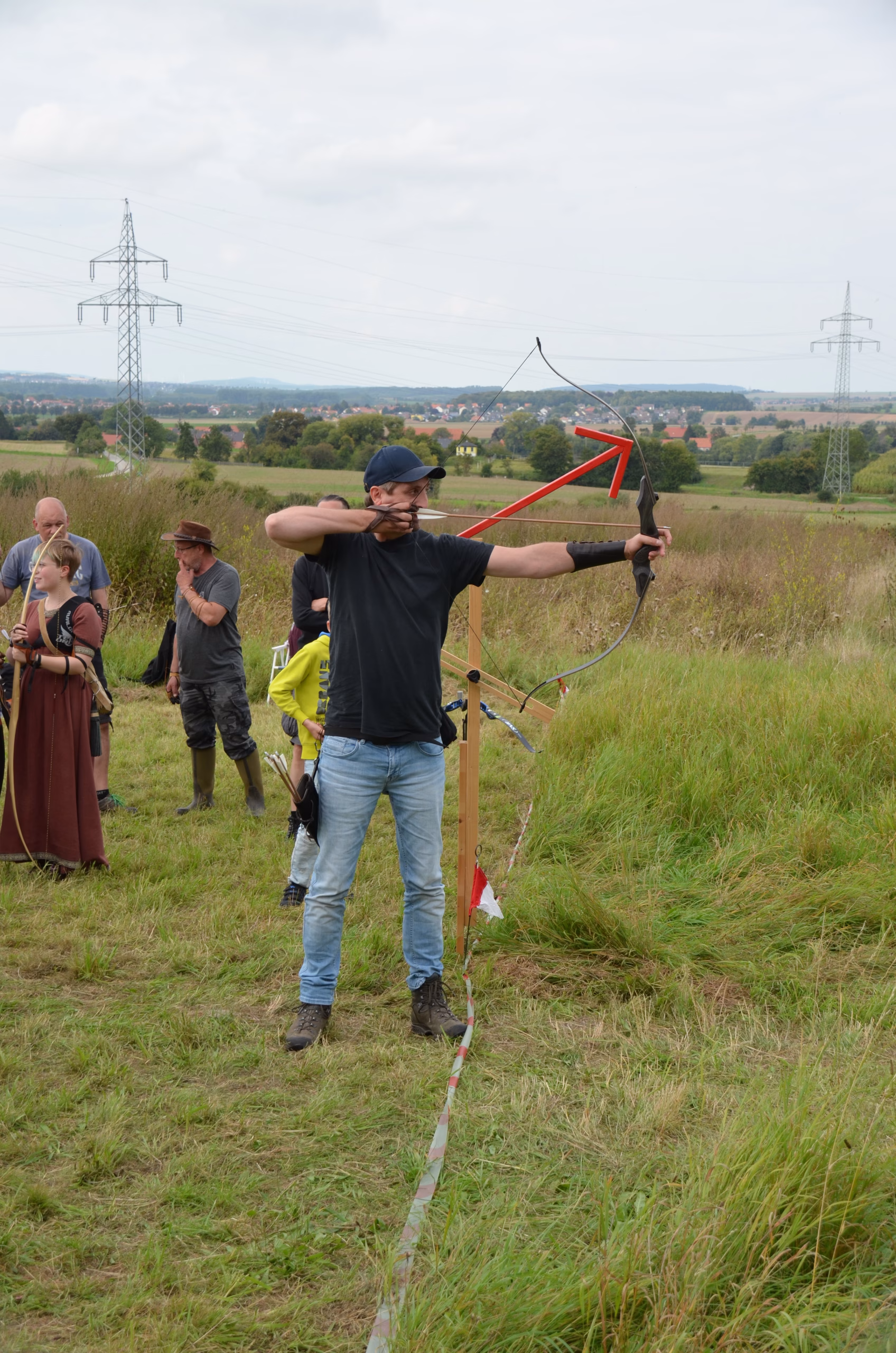 Ein Bogenschütze zielt mit seinem Bogen beim Clout-Bogenschießen-Wettbewerb in Siebenberge, veranstaltet von Pfeilflugkunst.