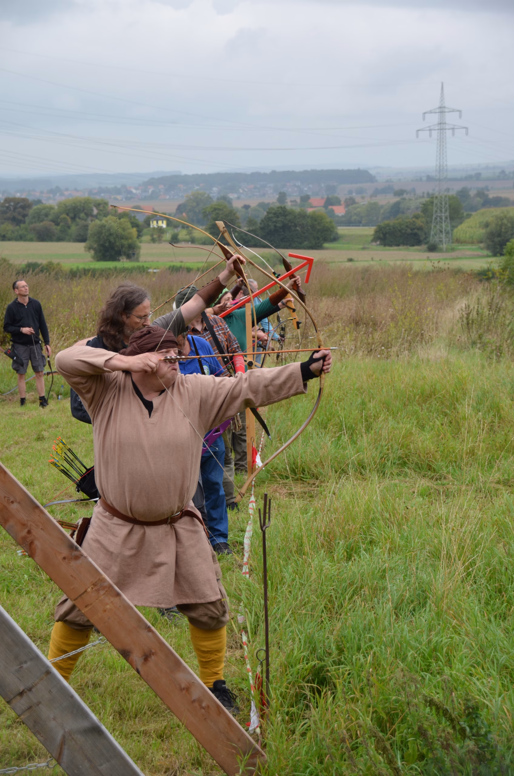 Bogenschütze in traditioneller Kleidung beim Clout-Bogenschießen während des Siebenberge Clout Bogenwettbewerbs 2021 von Pfeilflugkunst.