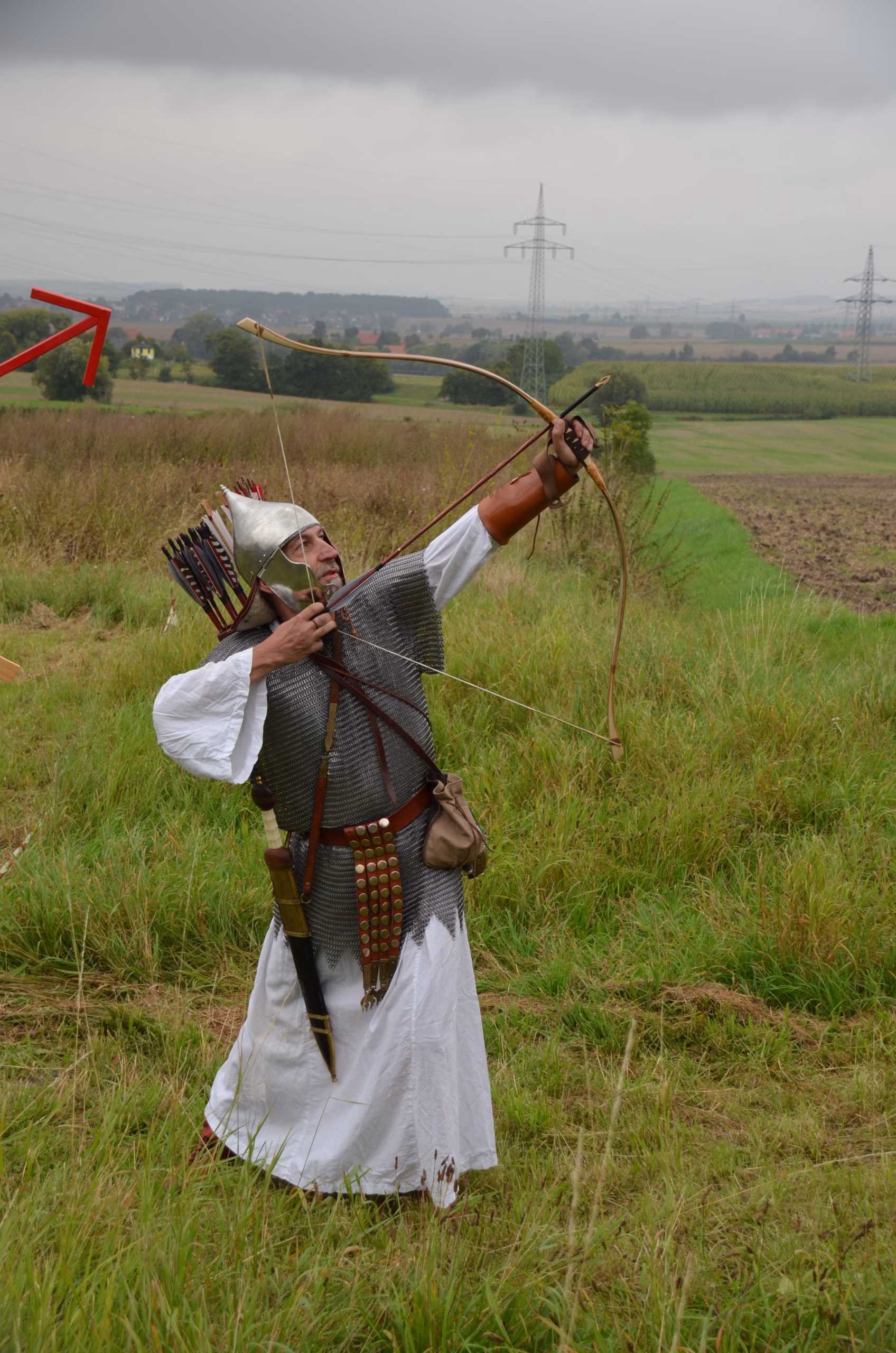 Bogenschütze in Kettenhemd und Helm beim Clout-Bogenschießen in Siebenberge, veranstaltet von Pfeilflugkunst.