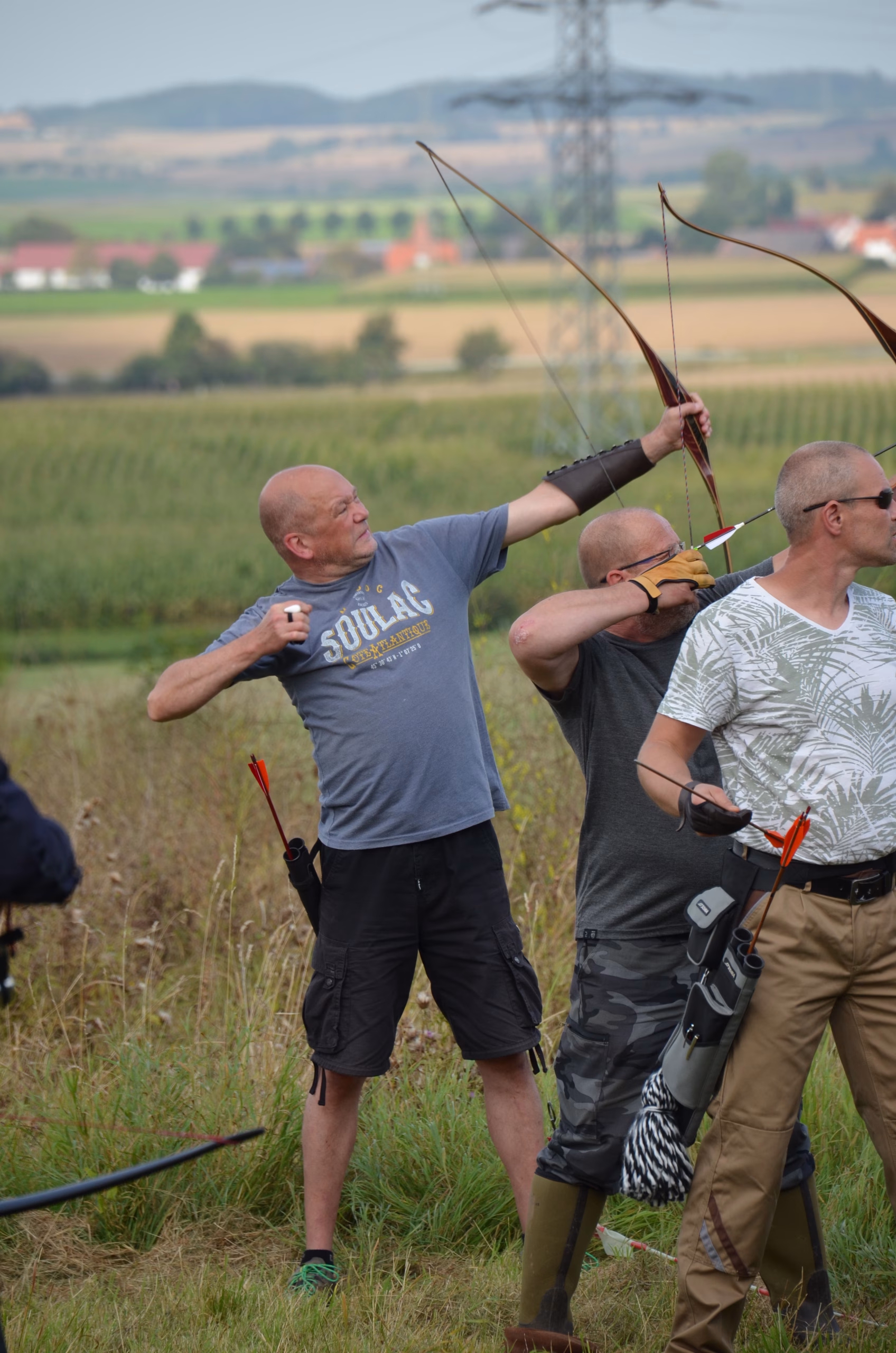 Ein Bogenschütze beim Clout Bogenschießen in Siebenberge, zielt mit einem traditionellen Bogen auf das weit entfernte Ziel.