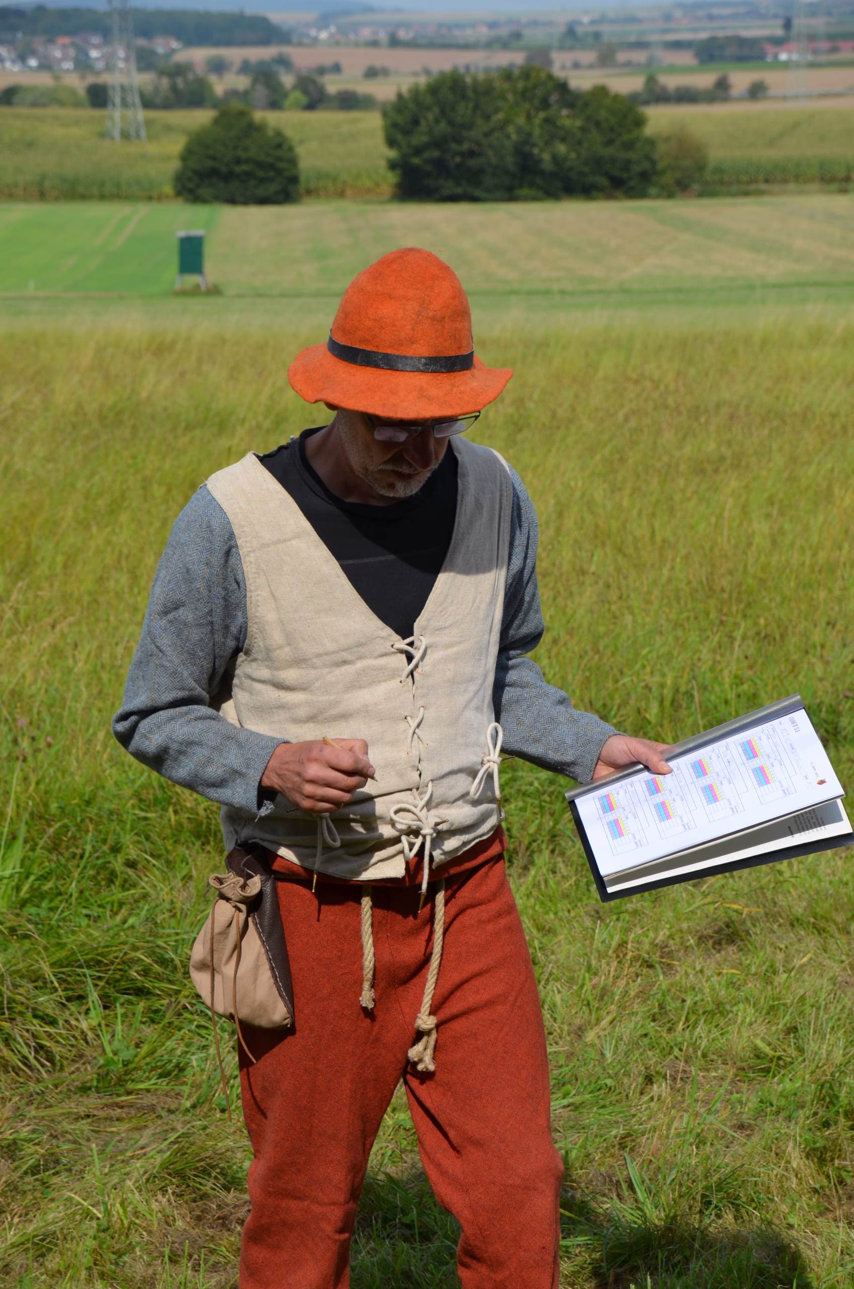 Bogenschütze in historischer Kleidung prüft Ergebnisse beim Siebenberge Clout Bogenwettbewerb von Pfeilflugkunst.