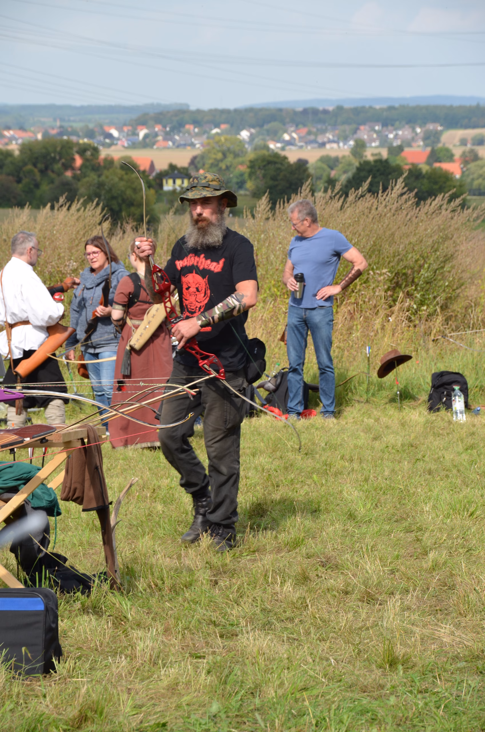 Bärtiger Bogenschütze mit Camouflage-Hut und modernem Bogen beim Siebenberge Clout Bogenwettbewerb 2021 von Pfeilflugkunst.