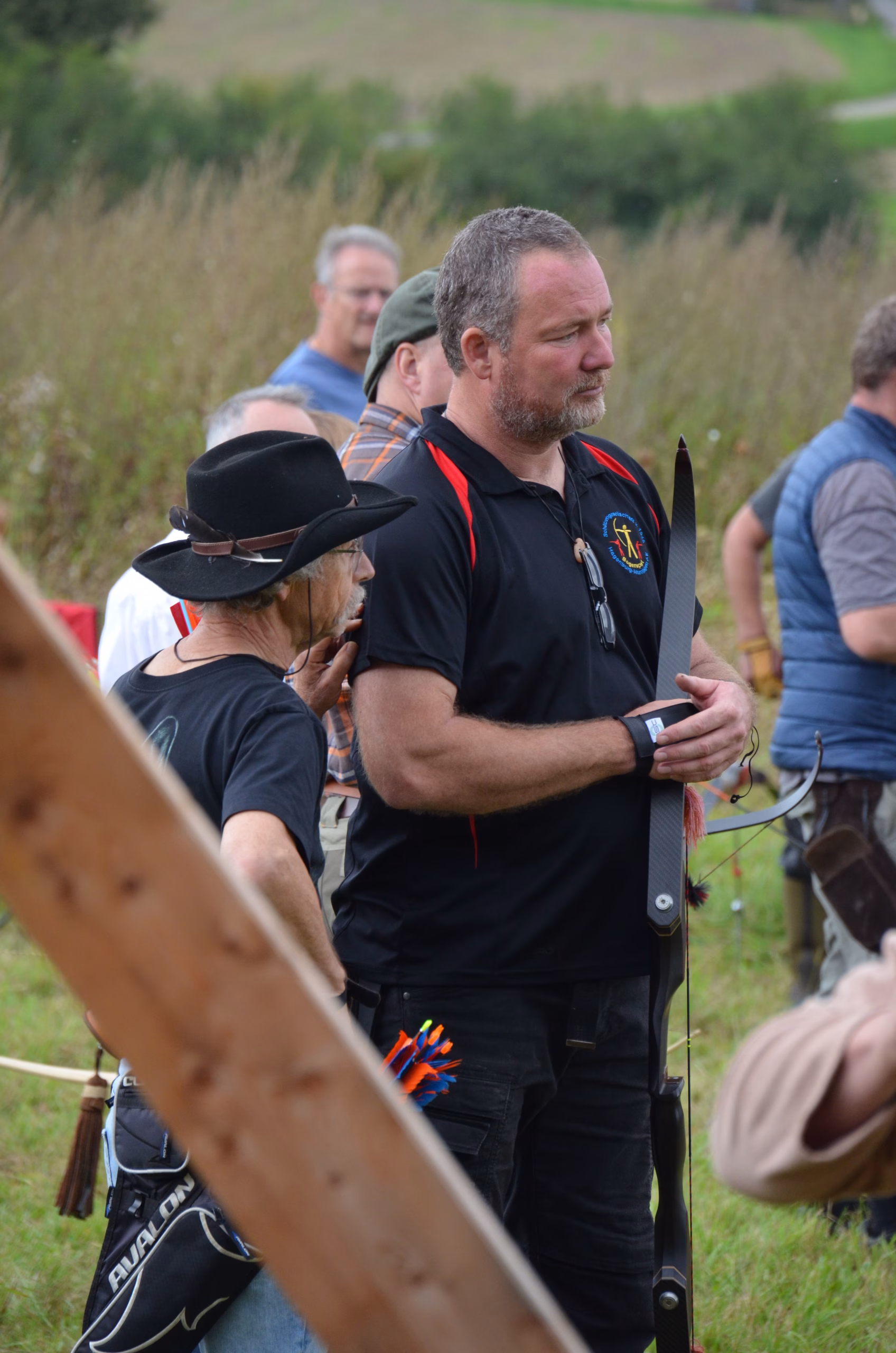 Ein bärtiger Bogenschütze mit Recurvebogen konzentriert sich beim Clout-Bogenschießen-Wettbewerb in Siebenberge, veranstaltet von Pfeilflugkunst.