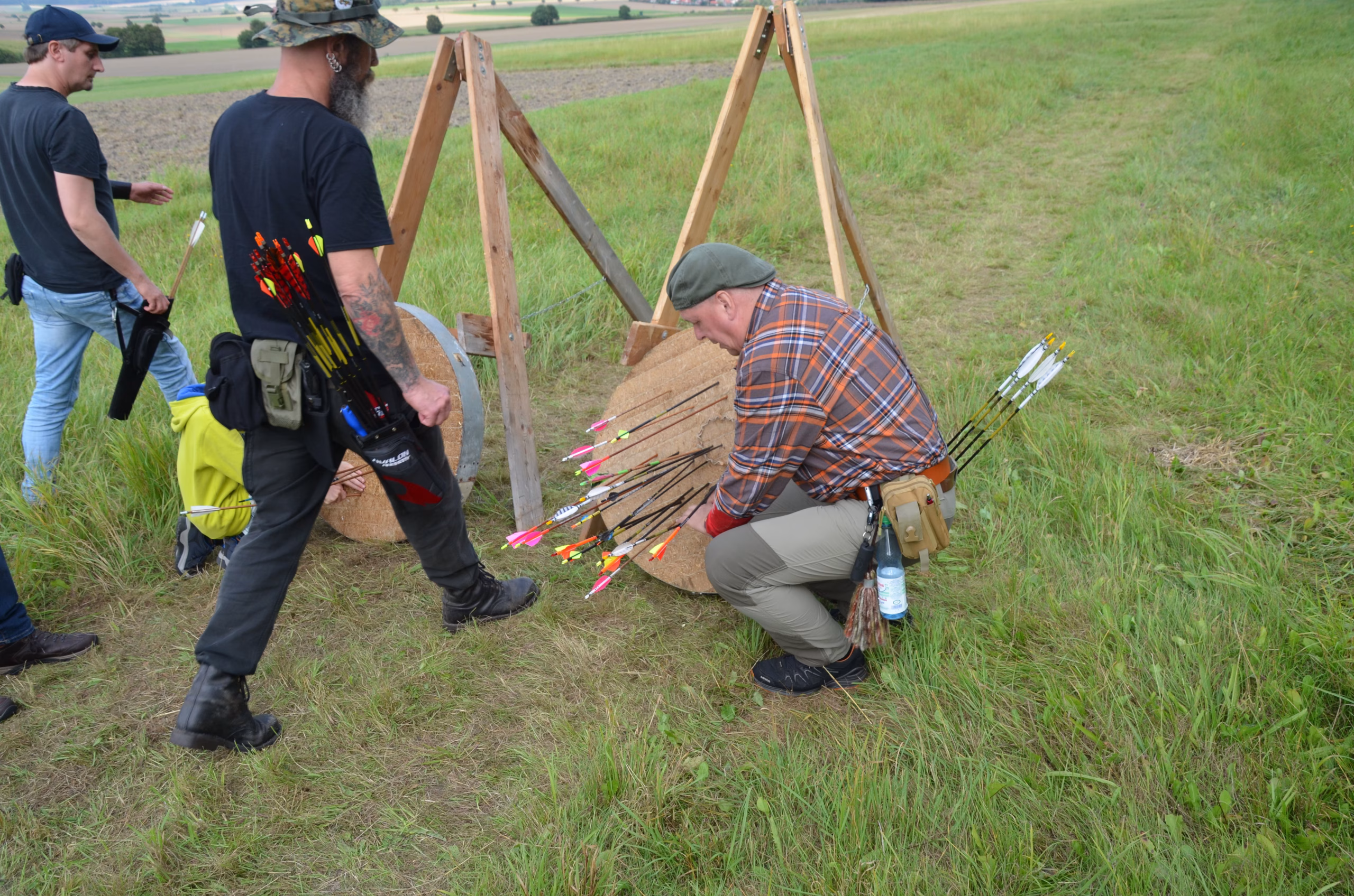 Bogenschützen ziehen Pfeile aus dem Ziel beim Siebenberge Clout Bogenwettbewerb von Pfeilflugkunst.