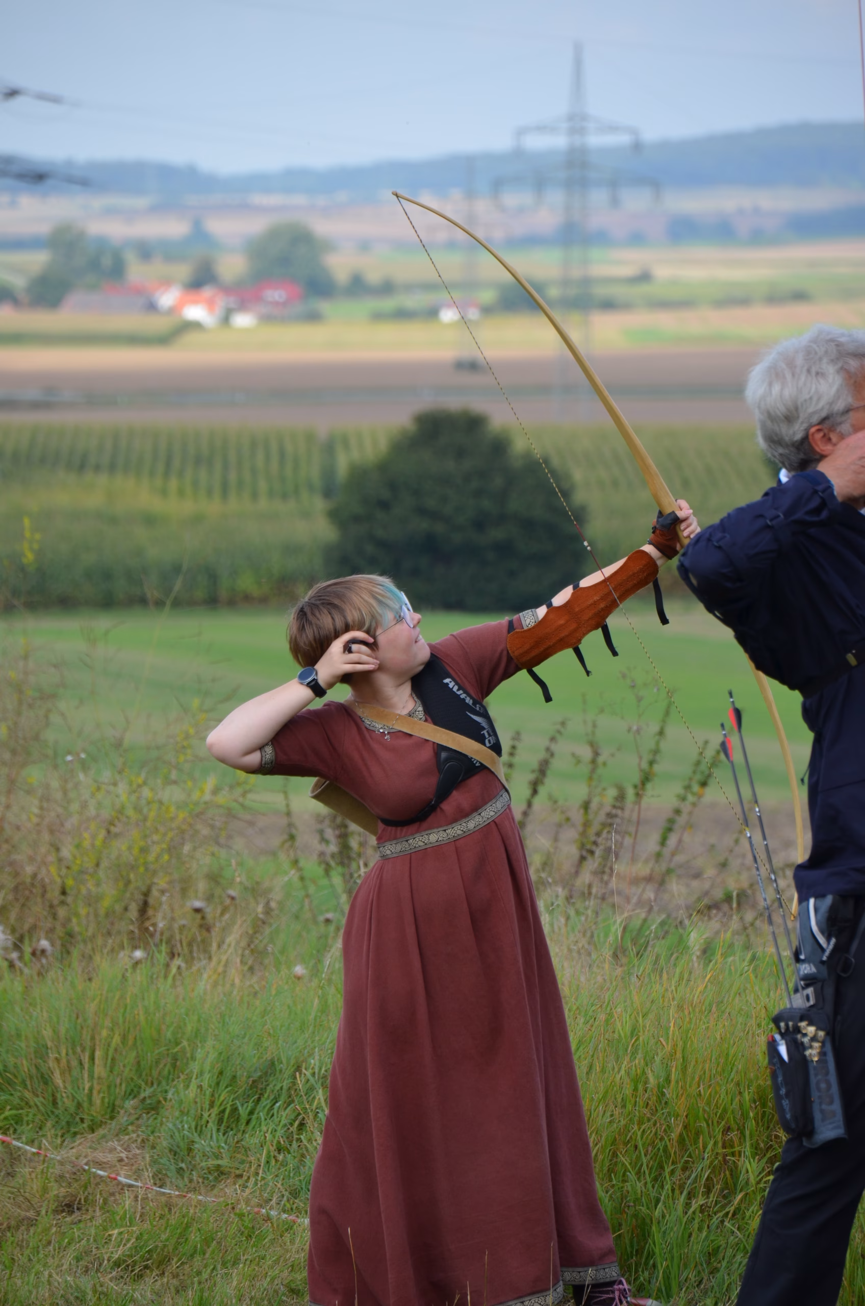 Junge Bogenschützin in traditionellem Gewand beim Clout Bogenschießen des Pfeilflugkunst Wettbewerbs in Siebenberge 2021.