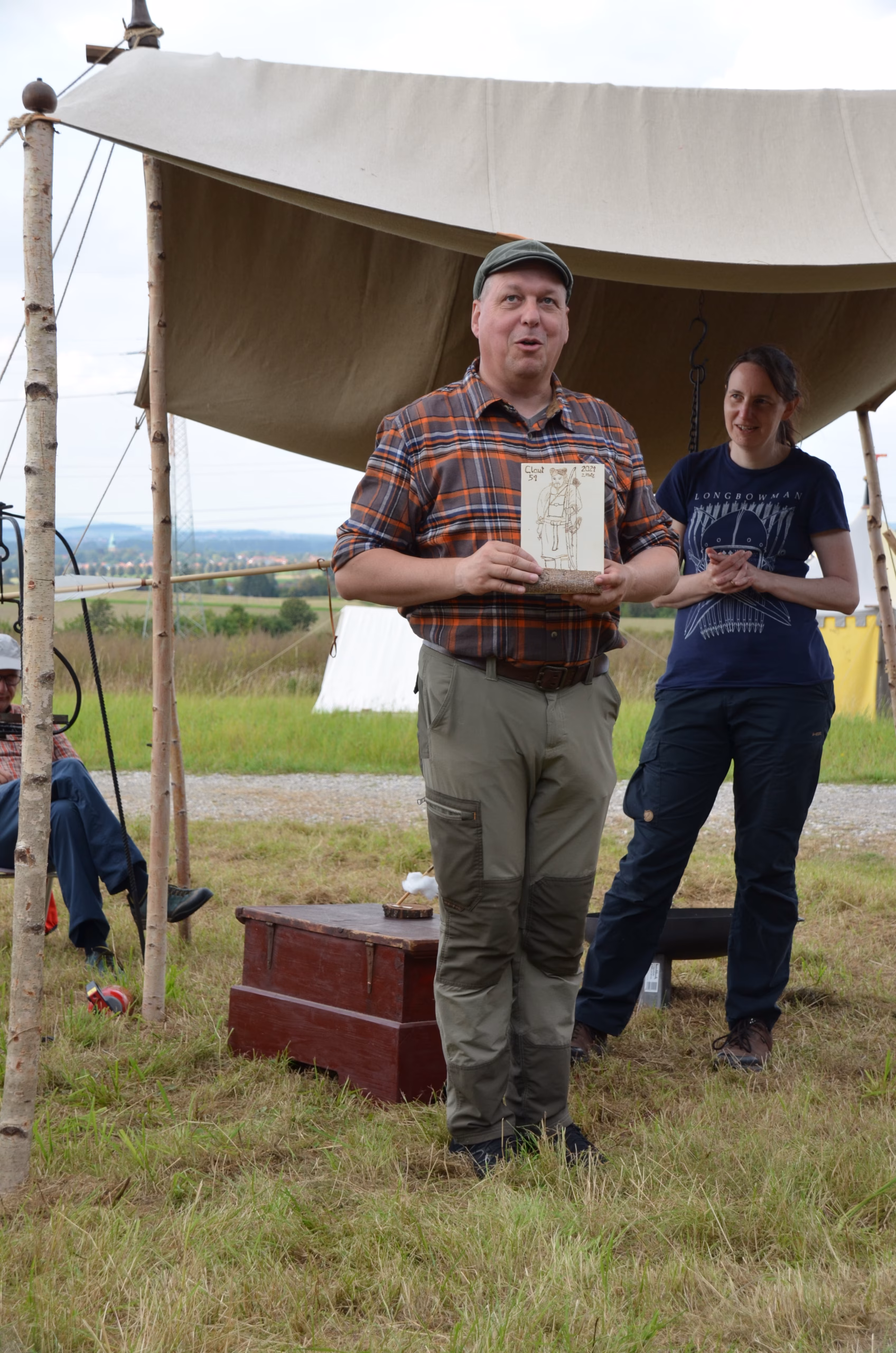 Mann bei der Siegerehrung des Siebenberge Clout Bogenwettbewerbs 2021 von Pfeilflugkunst, hält eine Auszeichnung.